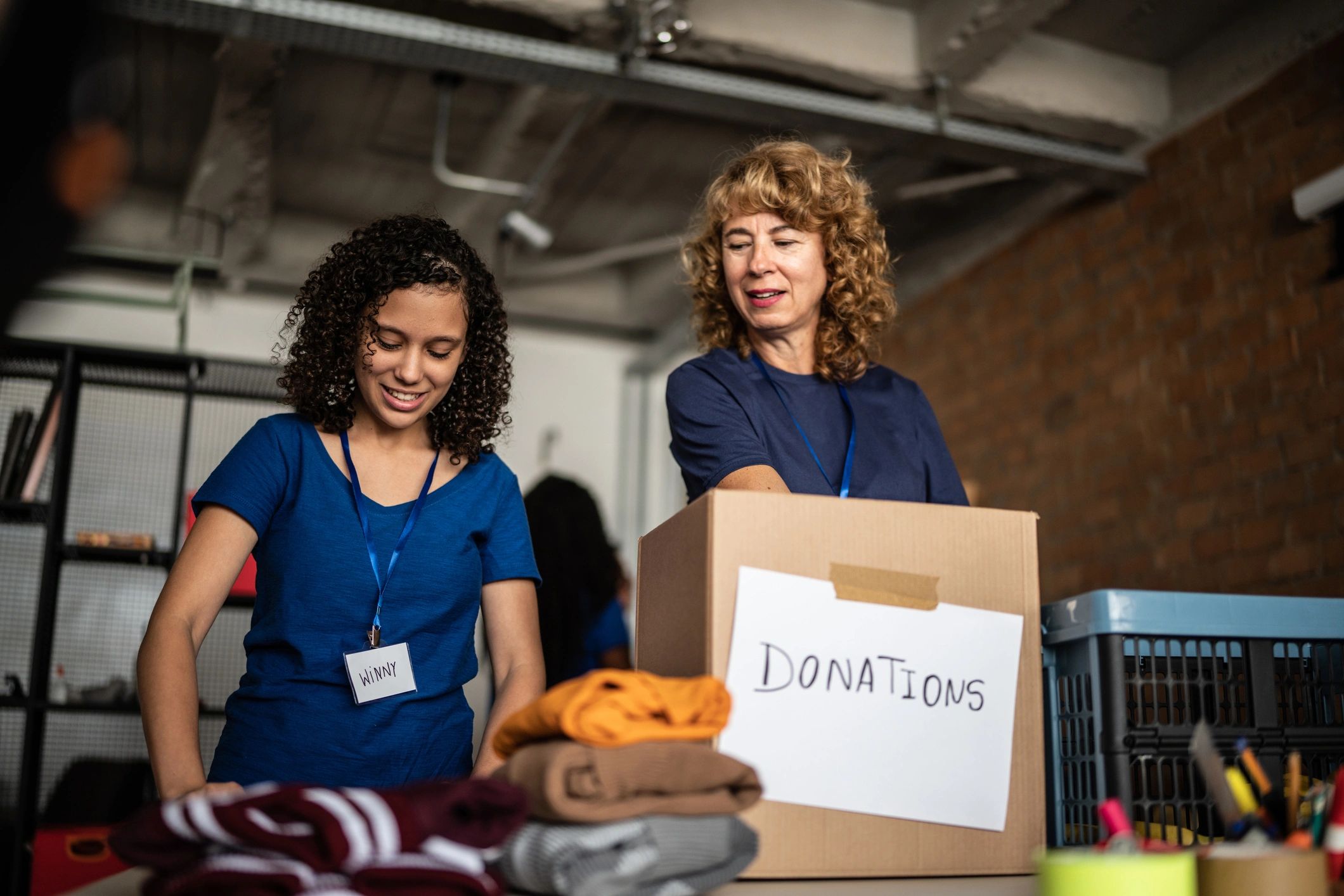 Two women sorting donations in a community center.