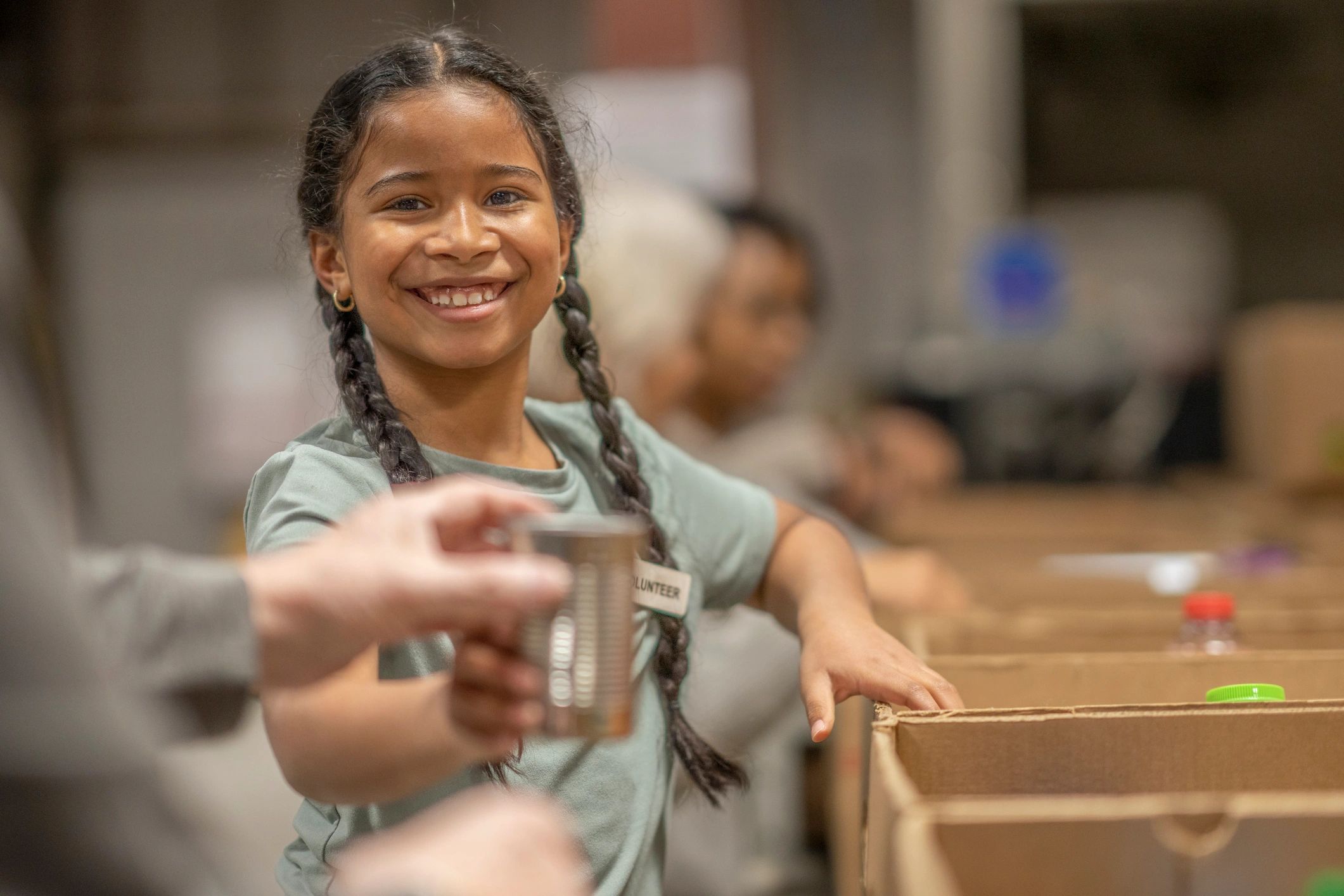 Smiling girl helping with food distribution at a community center.
