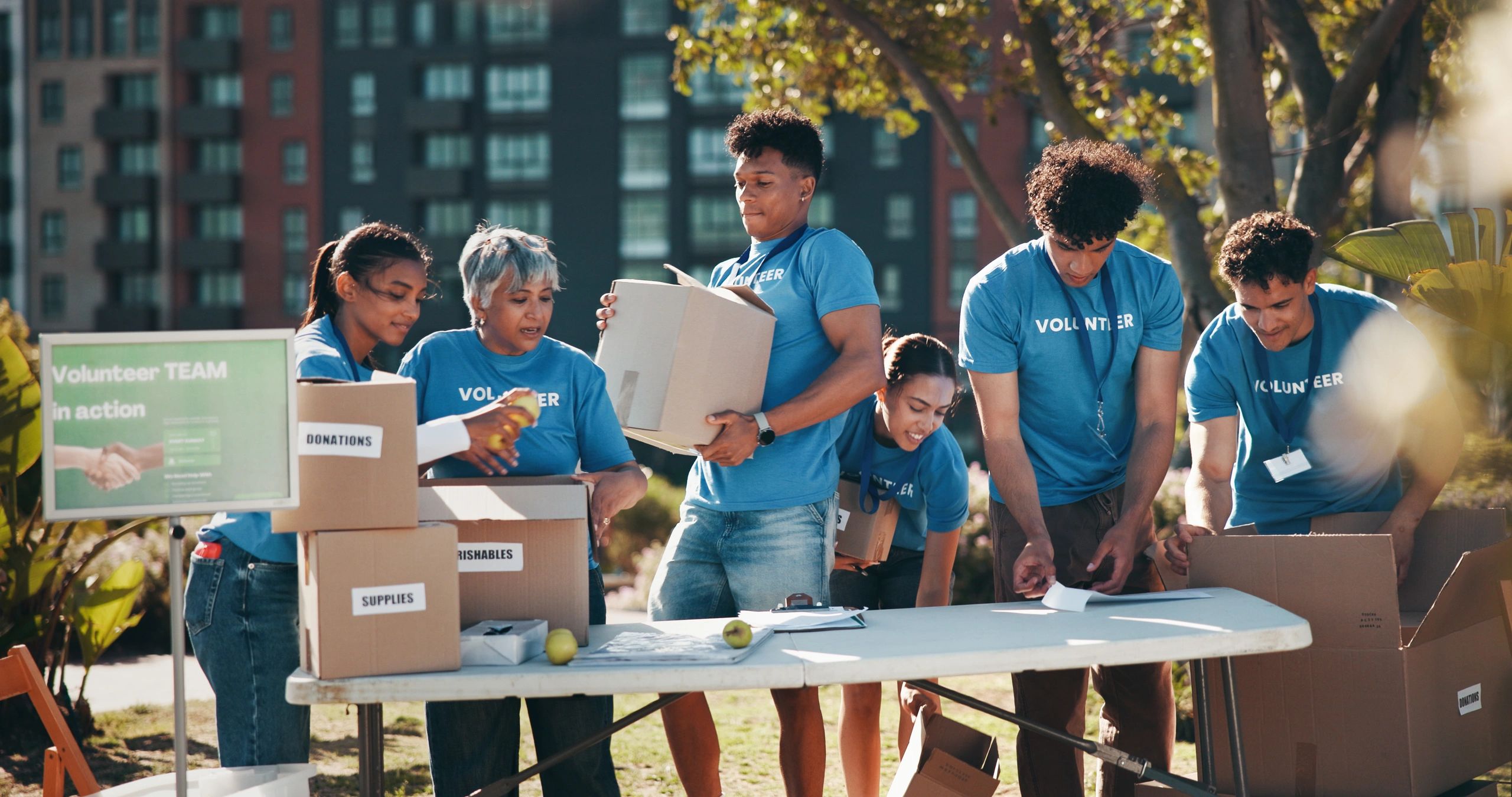 Volunteers organizing and packing boxes outdoors at a community event.