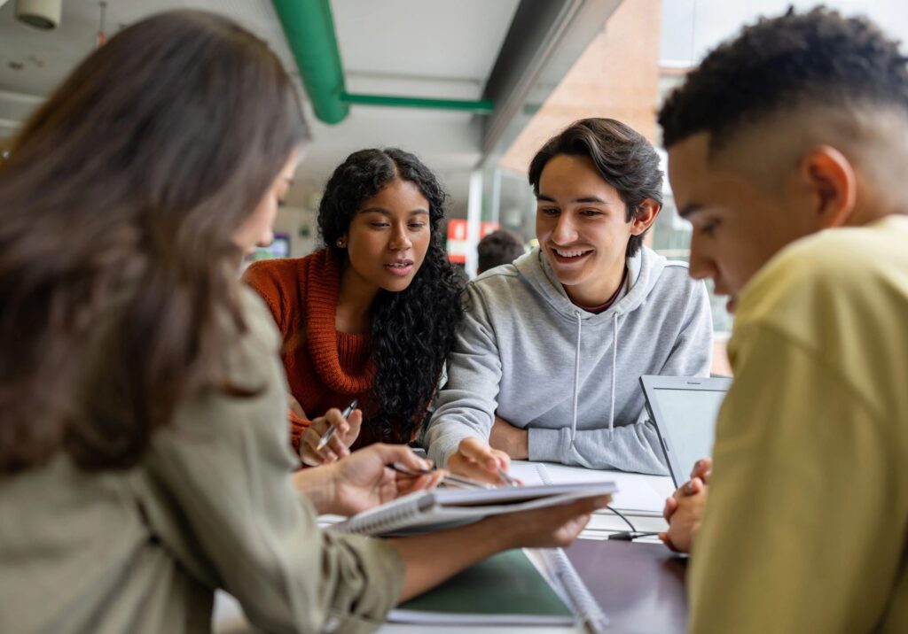 Four young adults collaborating and discussing notes together.