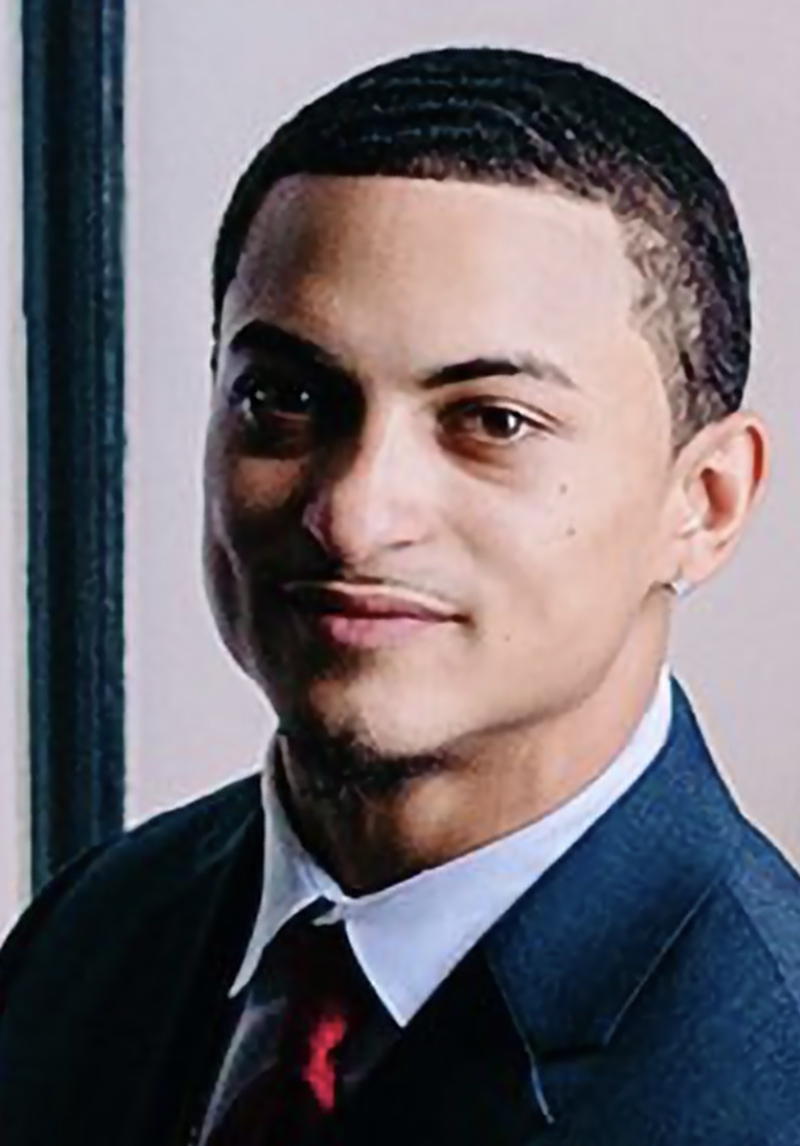 Portrait of a young man in a suit with a confident expression.